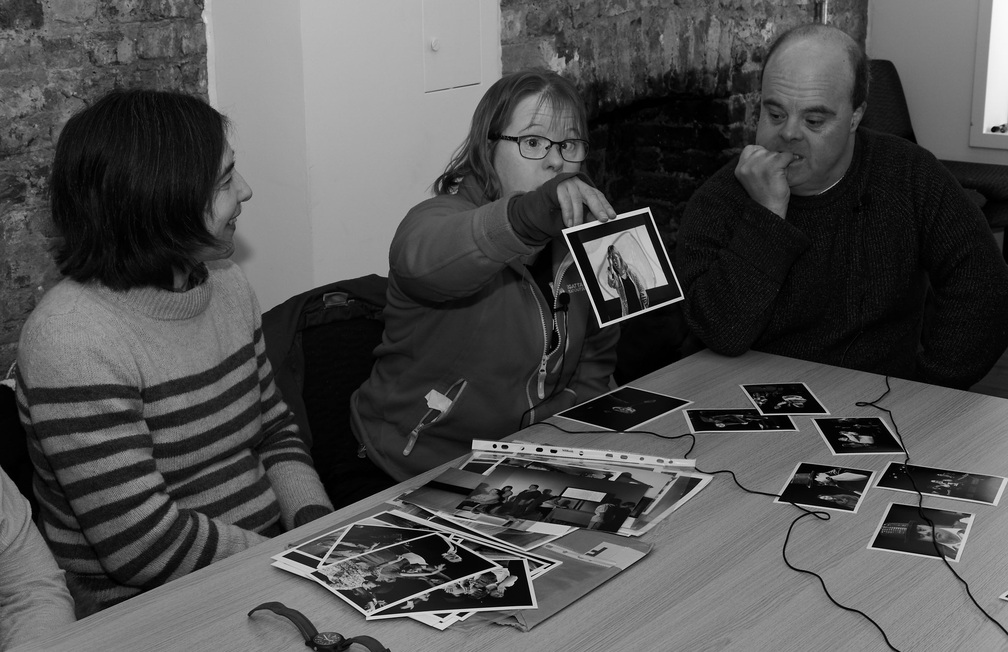 Bethan holding a photograph of herself at an interview with other people smiling